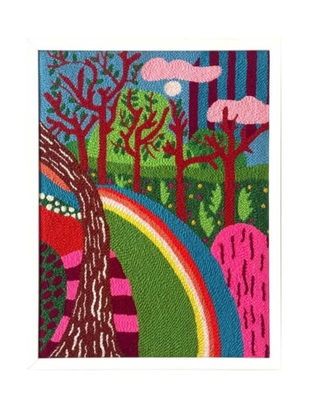 Tableau textile coloré représentant une forêt stylisée avec un arc-en-ciel, brodé à la main en punch needle.