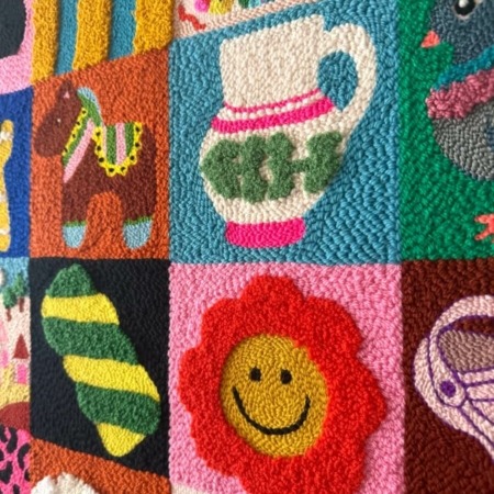 Tableau textile brodé de seize petits motifs colorés inspirés des jeux de mémoire, idéal pour décorer une chambre d’enfant avec douceur et fantaisie