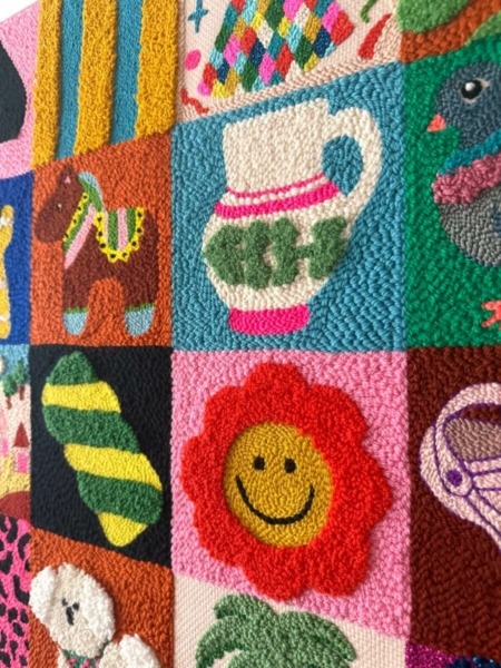 Tableau textile brodé de seize petits motifs colorés inspirés des jeux de mémoire, idéal pour décorer une chambre d’enfant avec douceur et fantaisie