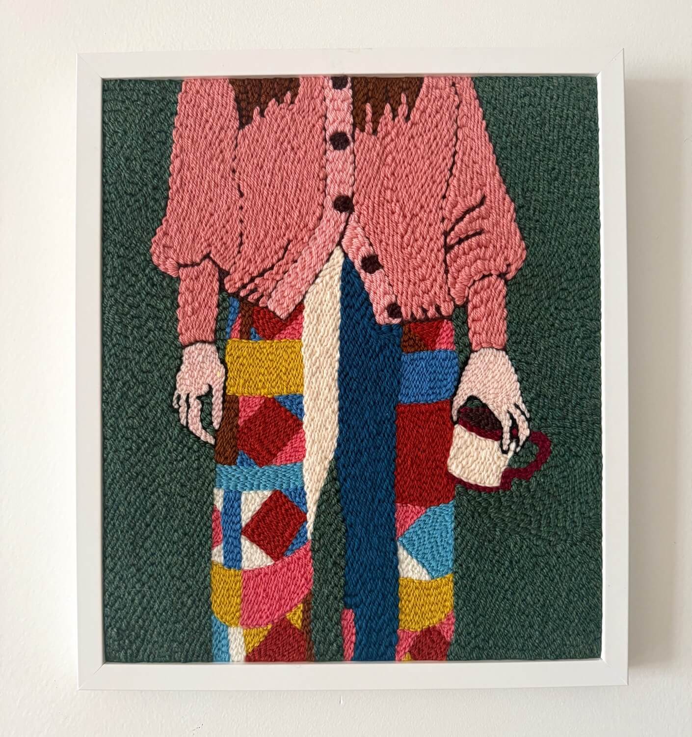 tableau textile rectangulaire représentant une femme en gilet rose avec un pantalon en patchwork coloré et tenant sa tasse de café à la main