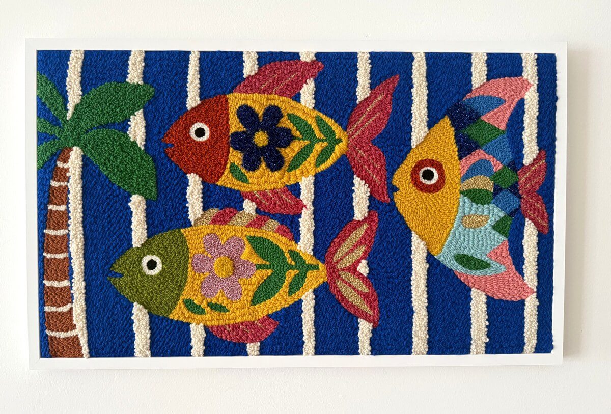 tableaux textile grand format rectangulaire représentant des poissons jaunes, rouges, verts et dorés sur un fond bleu vif avec des rayures écrues en relief et un palmier