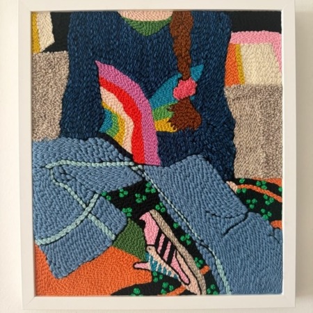 tableaux textile rectangulaire représentant une fille portant un pull bleu avec un arc-en-ciel, un jean bleu et des baskets